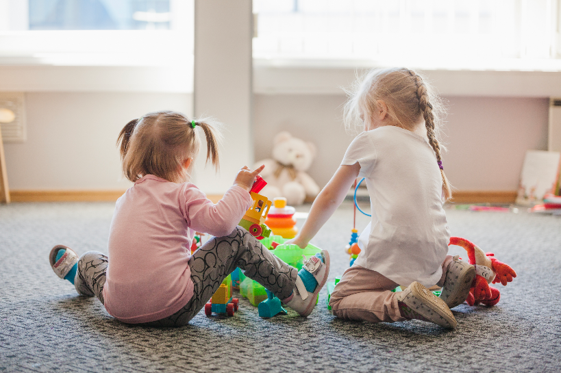 two little girls sitting floor playing